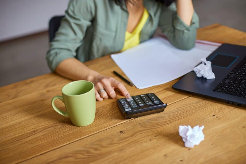 femme calcule le montant de ses APL sur une calculatrice