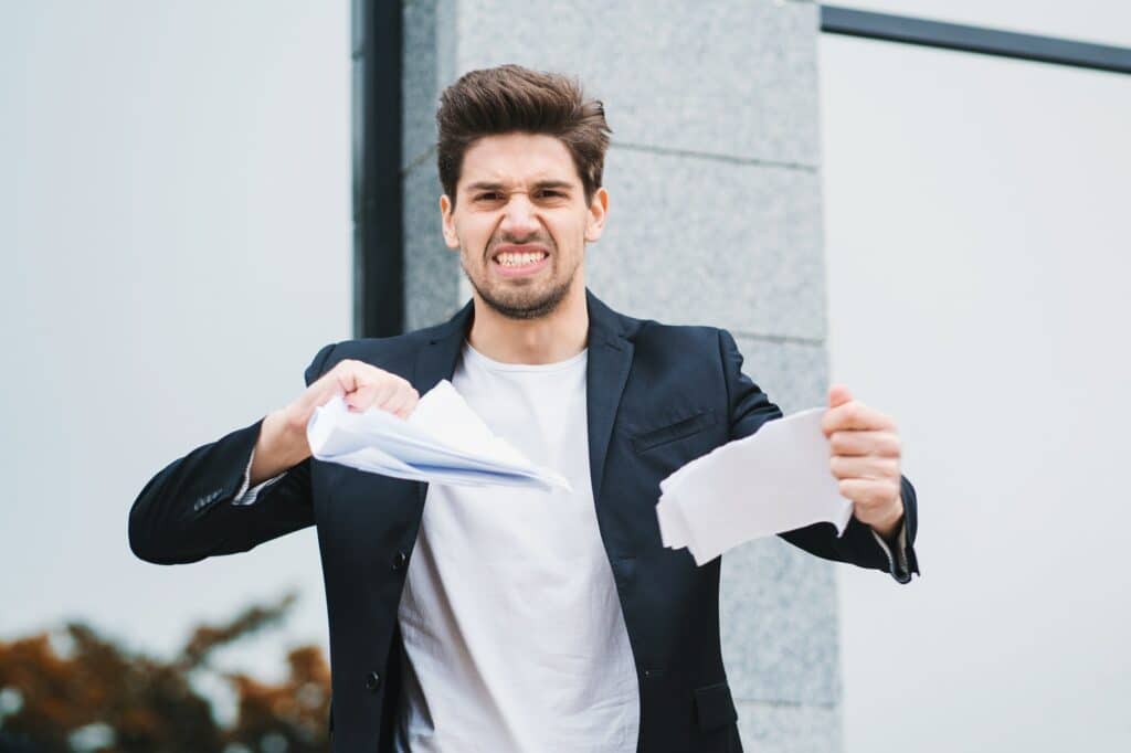 Serious businessman tearing contract in pieces